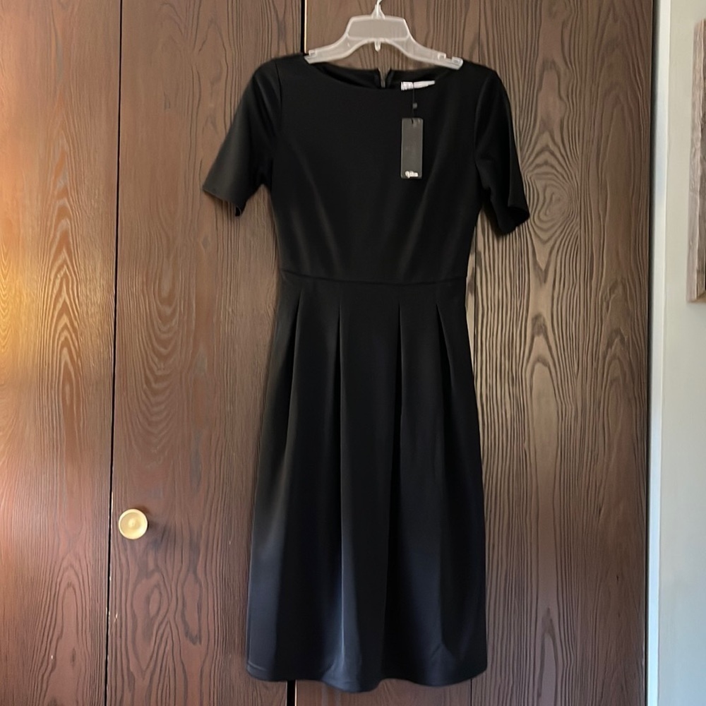 V female short sleeved, black midi dress. Pleated skirt area. NWT. Size Small